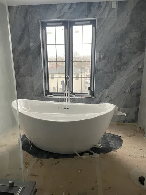 Freestanding soaking tub and stone-look walls